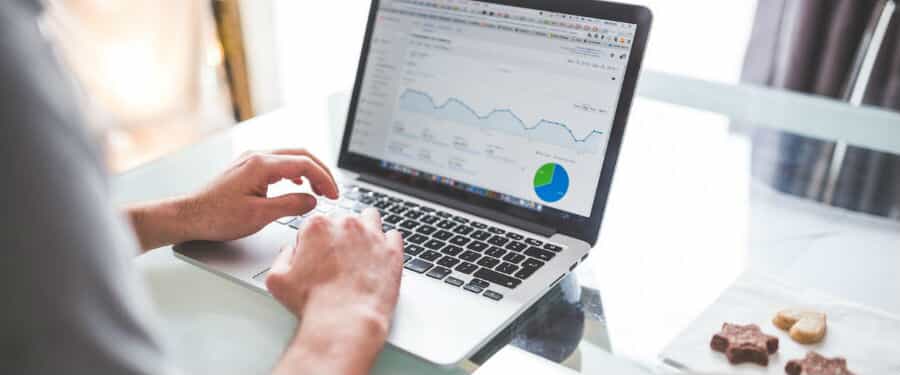 A man sits at a computer looking at graphs