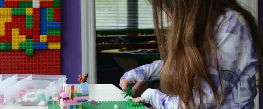 A young girl plays with Legos