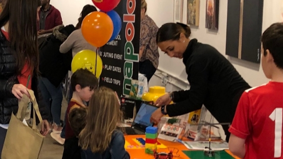 Jessica is at a table talking to children about snapology