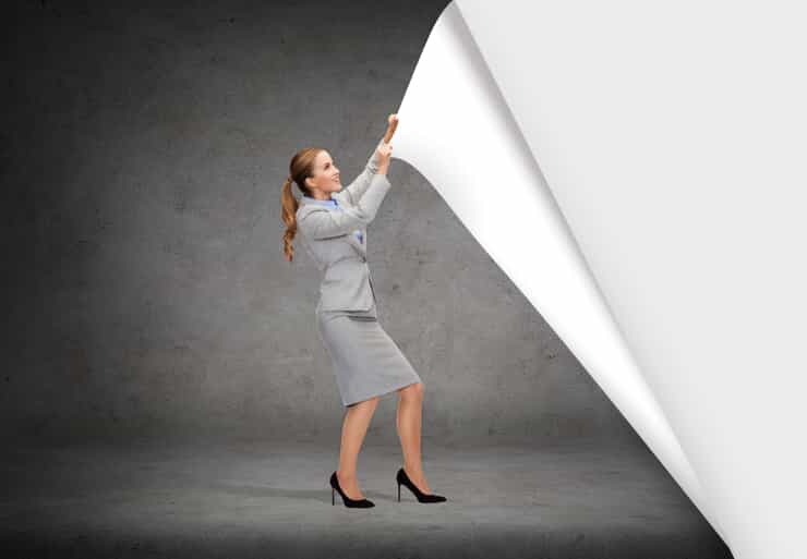 a business woman pulls at a large sheet of wallpaper