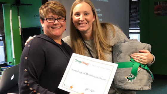Shannon poses with a woman holding a certificate for snapology