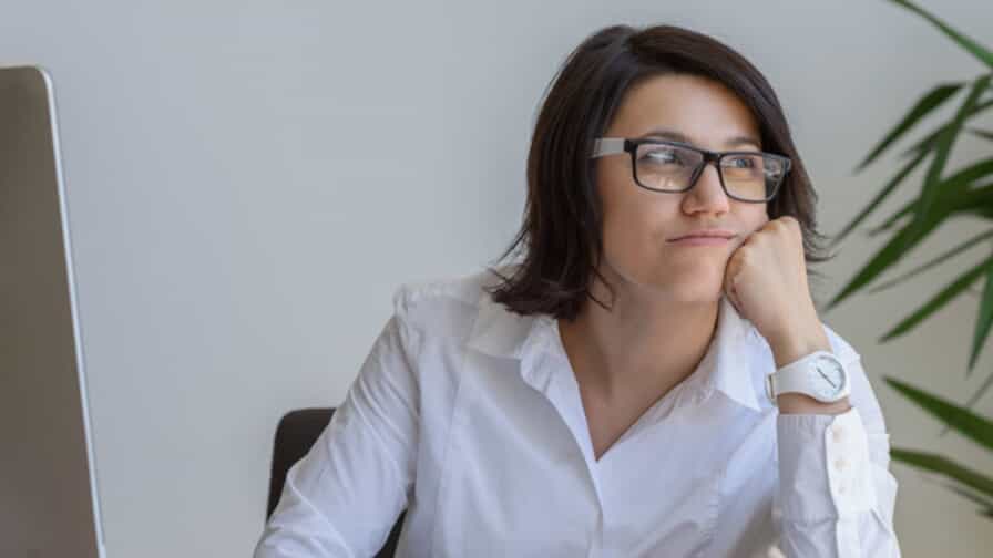 a young professional woman rests her head on her hand